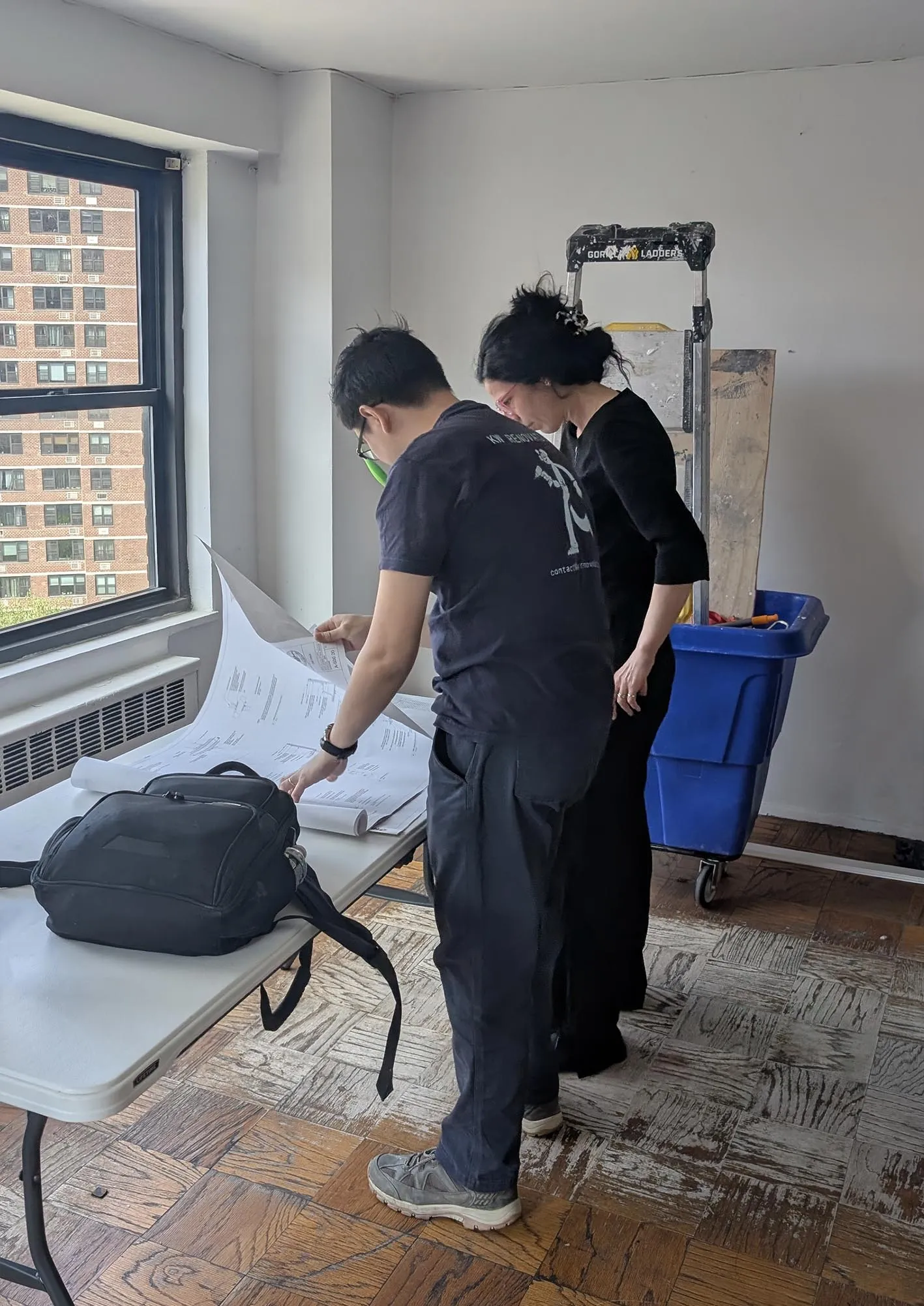 Architect reviewing construction drawings on site during a NYC apartment renovation
