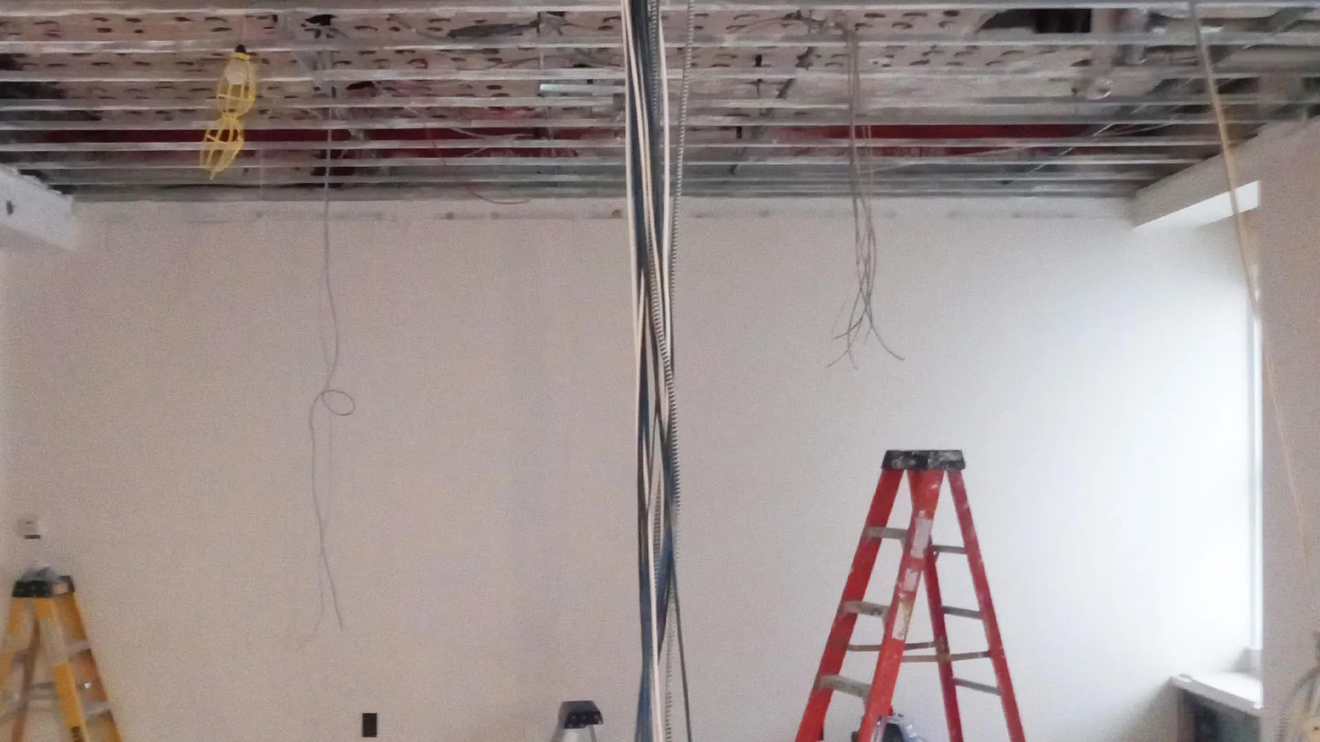 Gutted NYC apartment ceiling with exposed structure during renovation