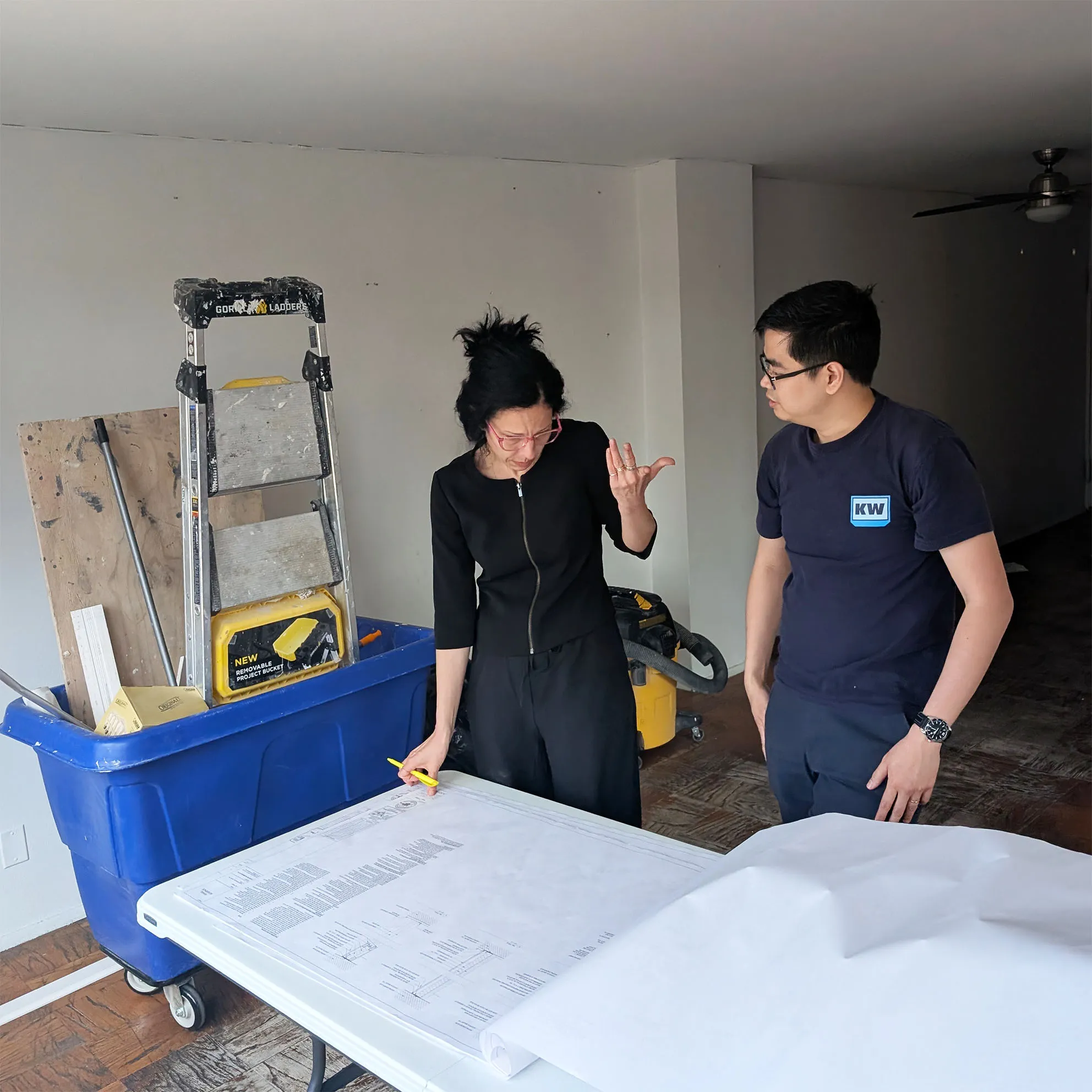 Architect Lenka Ilic reviewing construction drawings of full gut renovation with the general contractor at 268 East Broadway in Manhattan.
