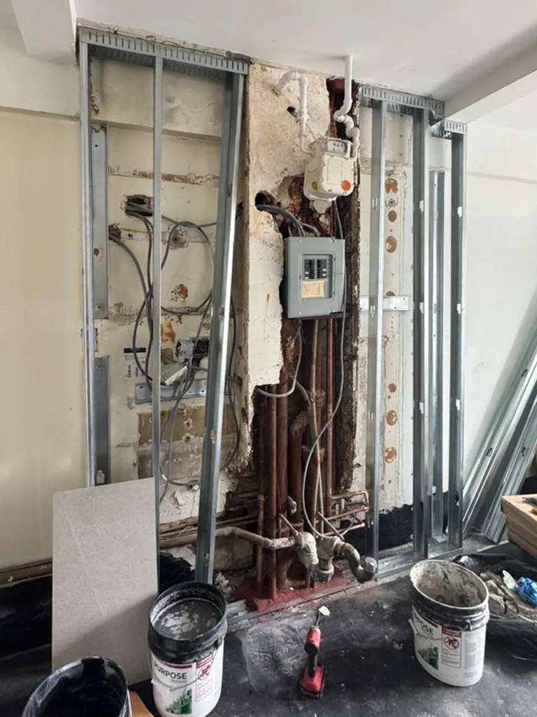 Prewar renovation demolition at 330 West 72nd Street exposing the electrical panel, gas meter, and existing wall conditions.