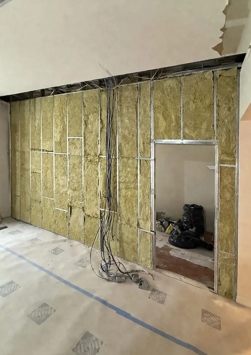 Two bedroom apartment renovation in the Financial District under construction, new insulated partitions with electrical wiring before drywall