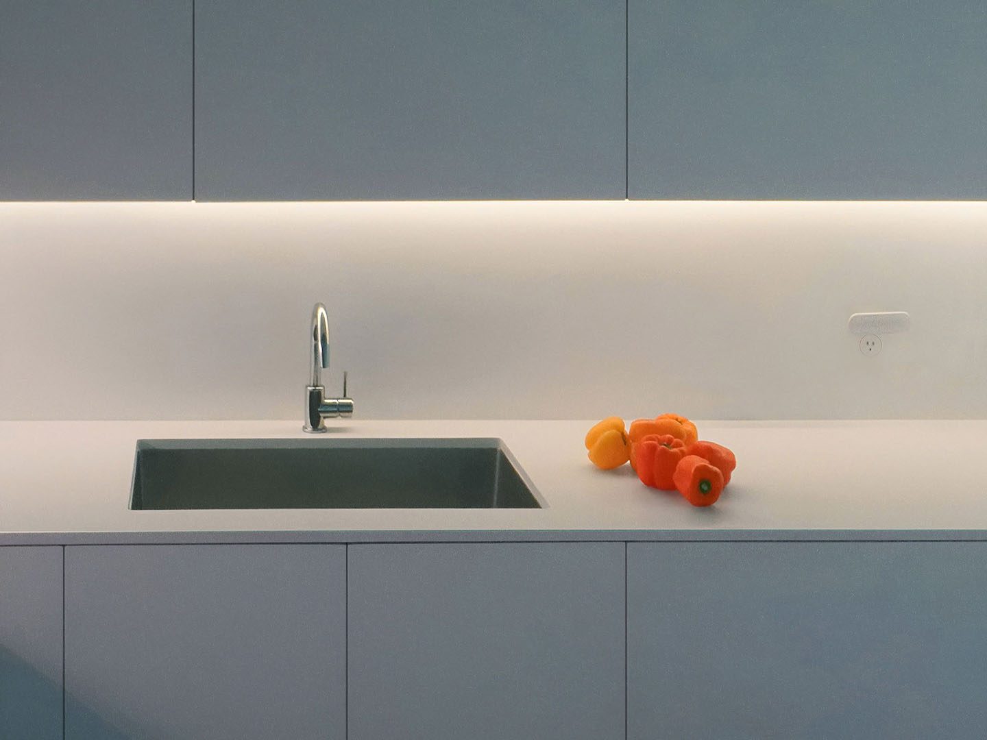 Kitchen remodel with grey-blue flat-panel cabinets, an undermount sink and under-cabinet lighting