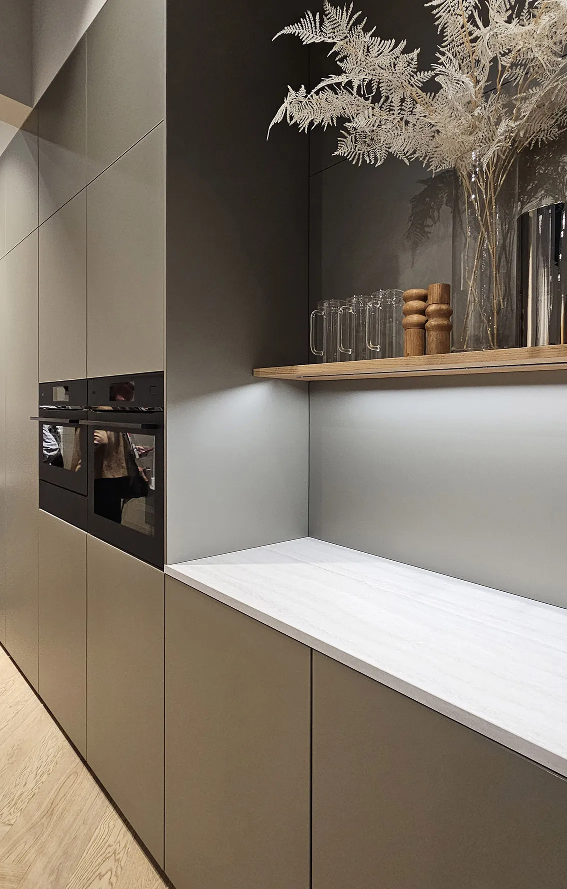 Custom millwork with undercabinet lighting and herringbone wood parquet flooring in a Manhattan prewar interior with built in appliances.