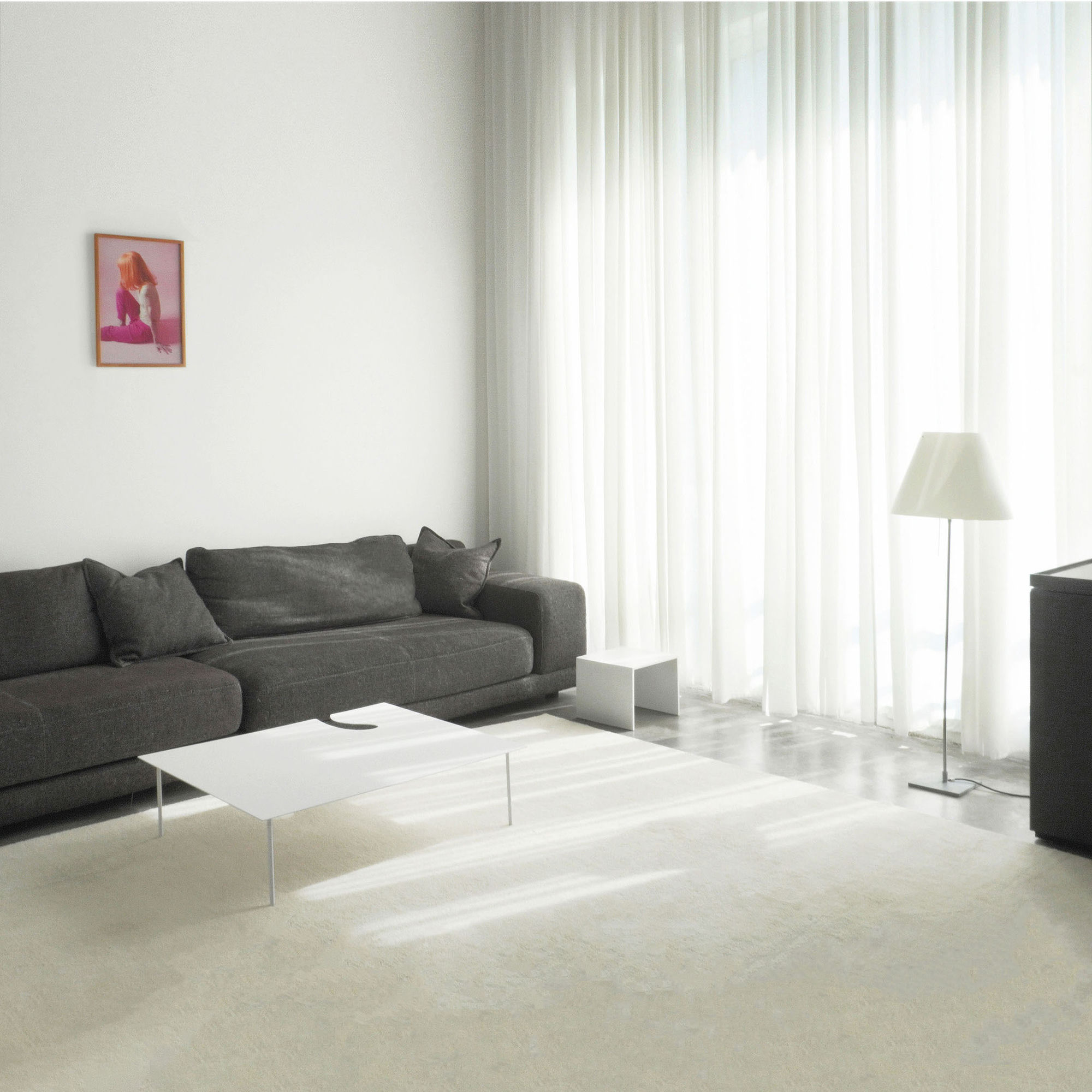 Apartment remodeling in NYC, interior design of a living room with a grey modular sofa, a low white table and floor-to-ceiling sheer curtains